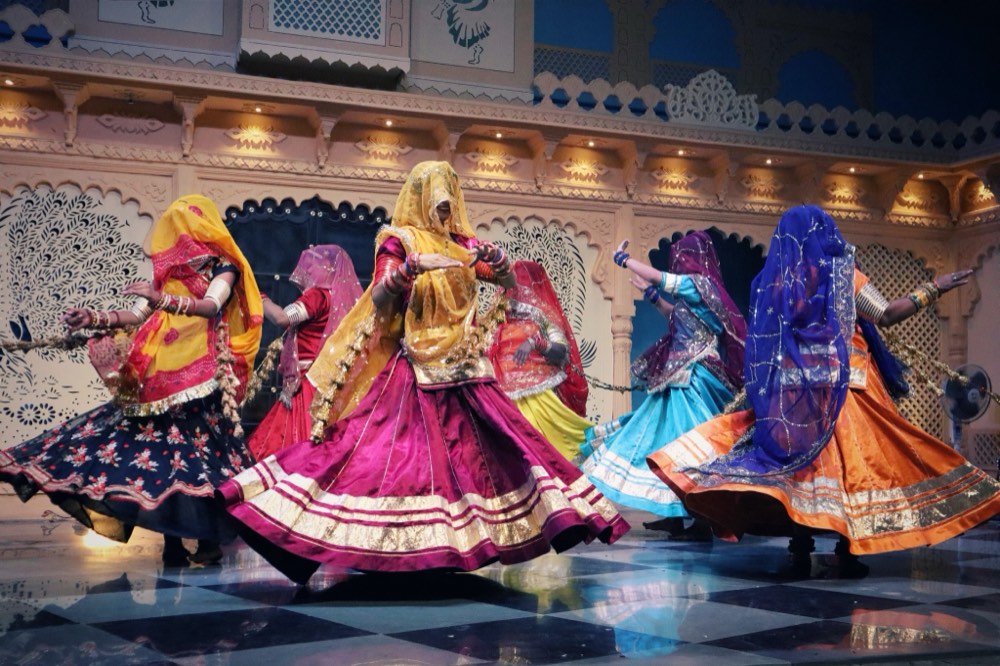 Ghoomar dancers mid-spin in pleated ghagra skirts